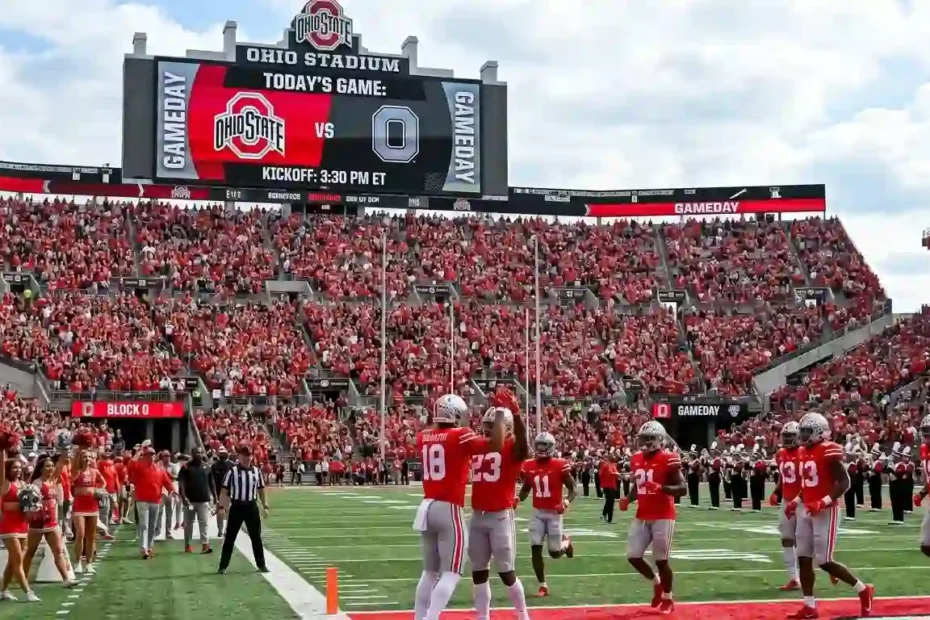 Ohio State Buckeyes football team on the field at Ohio Stadium during game day with fans in the stands.