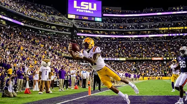 LSU Tigers American football player catching a pass inside Tiger Stadium during a college football game.
